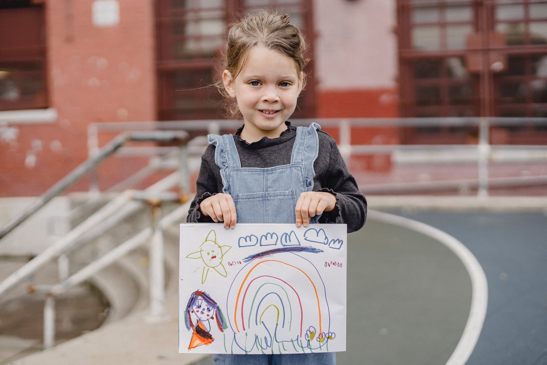 happy little girl showing colorful drawing
